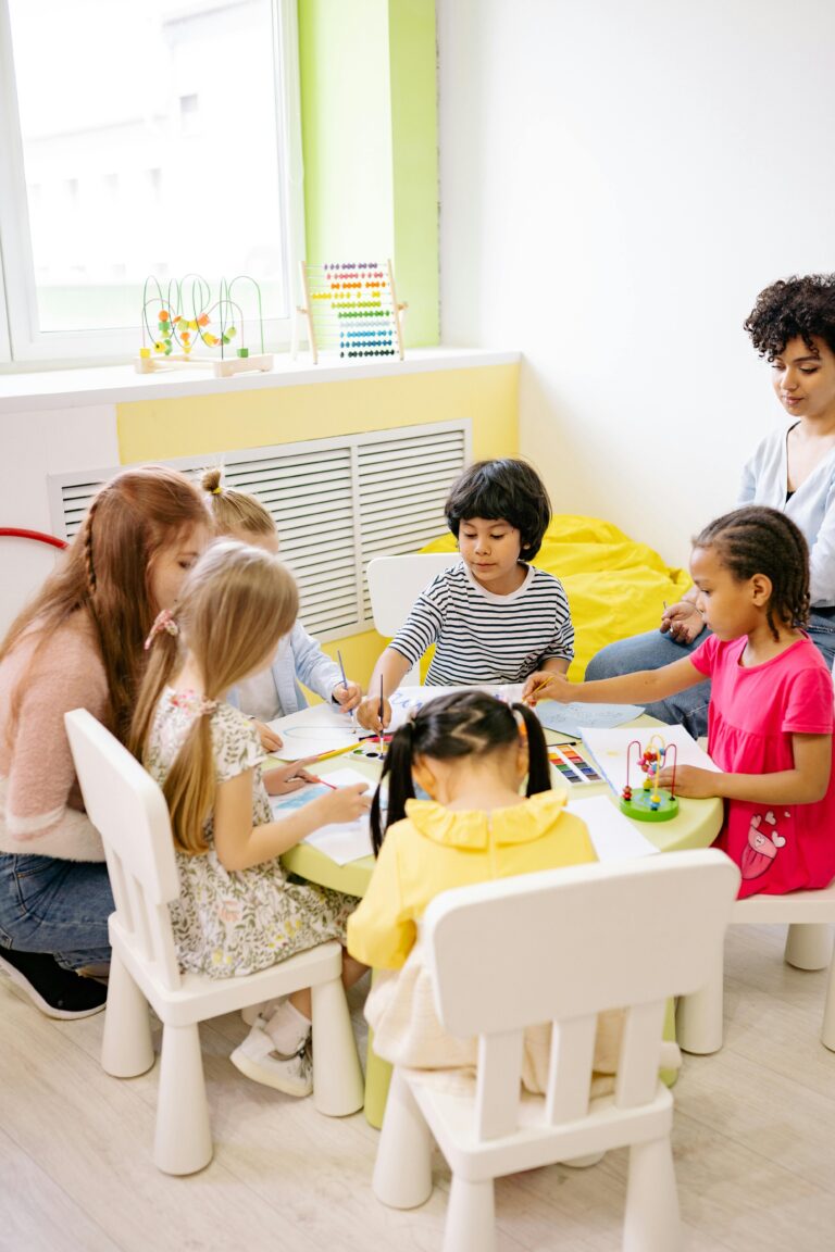 Children engaging in a creative arts and crafts session in a bright preschool classroom.